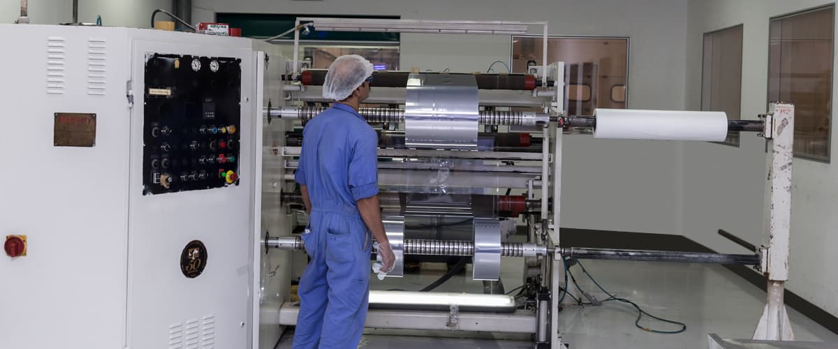 Team member operating an aluminium foil machine